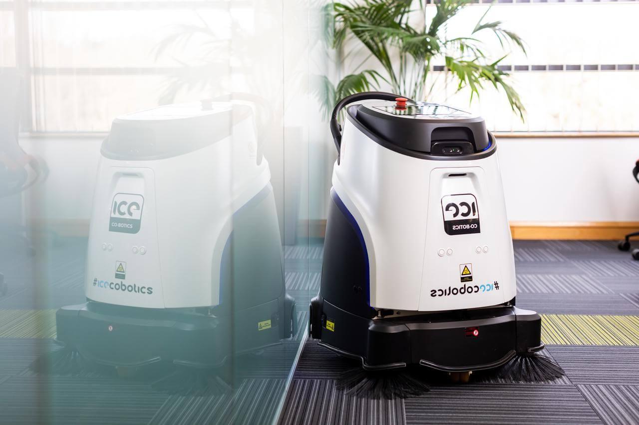 A white and black robotic vacuum cleaner in an office setting